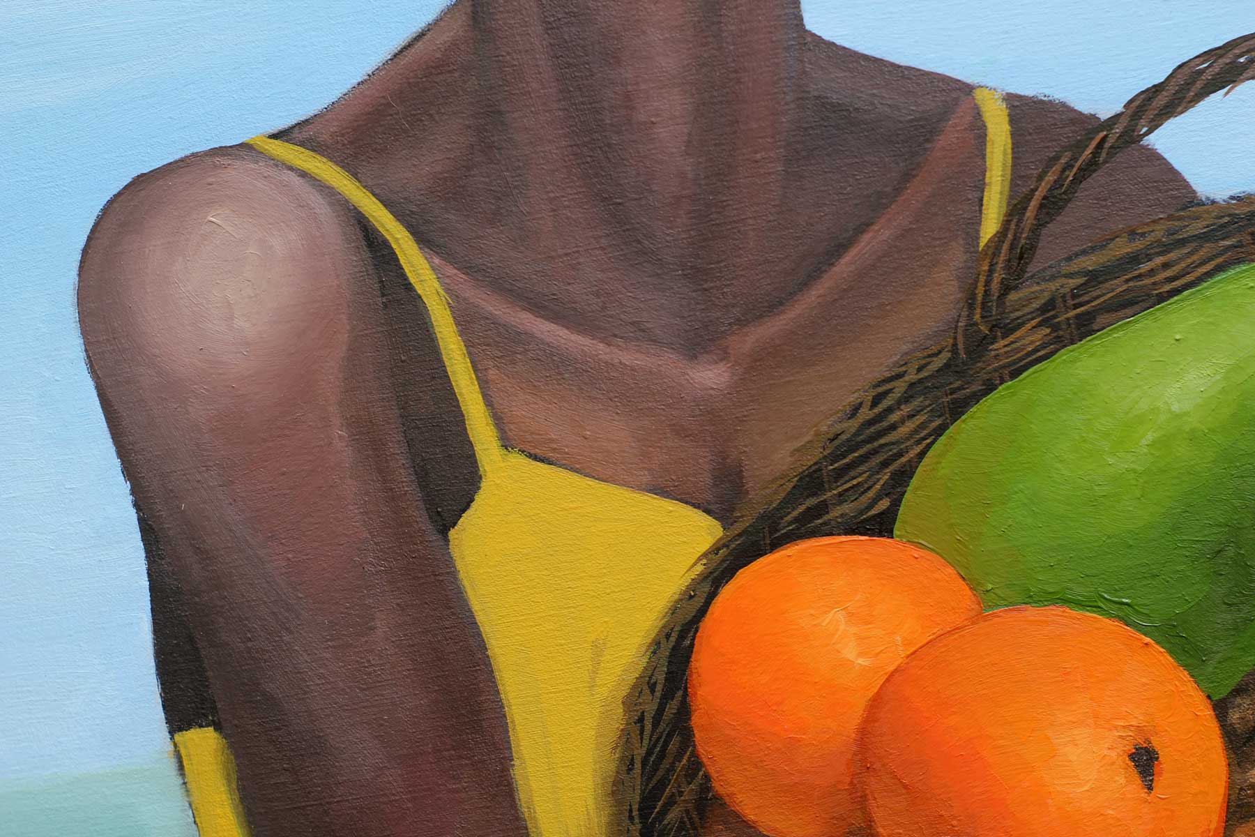Detail of the woman's yellow dress and neckline as she cradles a woven basket overflowing with tropical fruits, emphasizing the contrast between warm skin tones, bright yellow fabric, and richly colored produce.
